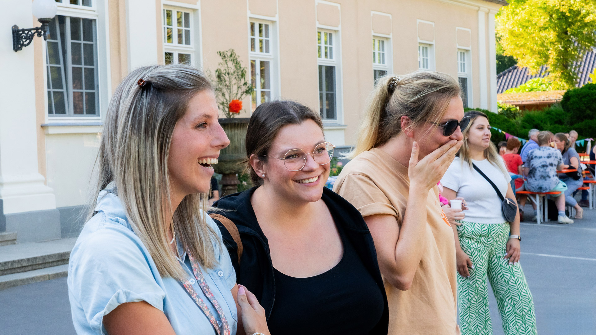 Ein Foto verschiedener Frauen, die draußen bei einer Veranstaltung des Sozialwerkes stehen und sich amüsieren.